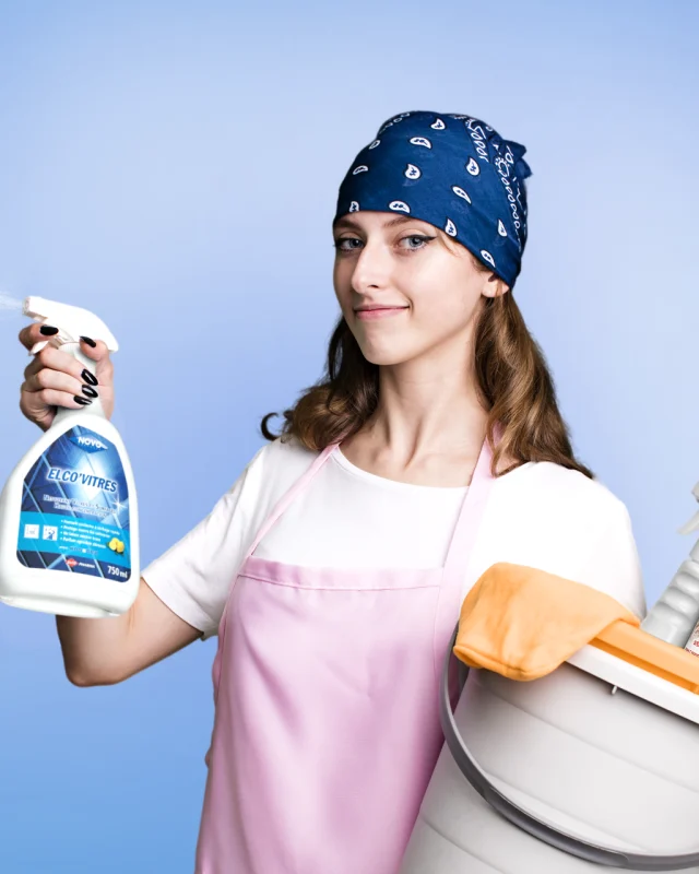 Gamme Novo Surfaces - femme de ménage avec des produits de nettoyage dans les mains sur fond bleu